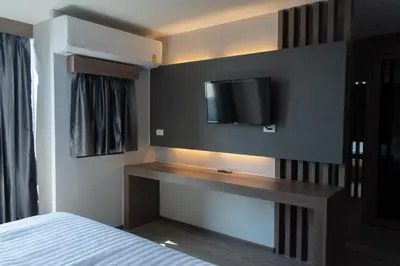 a bedroom with a bed and a tv on a wall at โรงแรมดับเบิ้ลดี ปากเกร็ด Double D hotel in Pak Kret