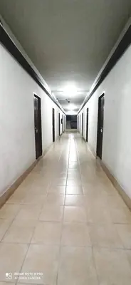 an empty hallway with doors and a tile floor at Jirapong apartment in Bangkok