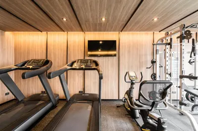 a gym with two treadmills and two ellipticals at Destiny63 Ekamai Apartment in Bangkok