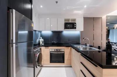 a kitchen with a stainless steel refrigerator and a sink at Destiny63 Ekamai Apartment in Bangkok