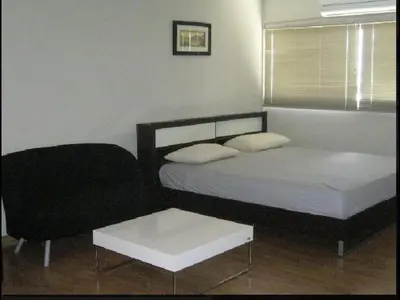 a bedroom with a bed and a chair and a table at Poppular Palace Don Mueang Bangkok, 5-minute drive from Impact Arena in Ban Bang Phang