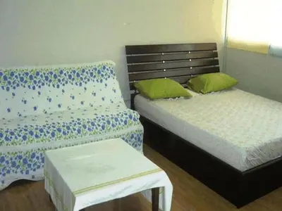 a bedroom with two beds and a bench in it at Poppular Palace Don Mueang Bangkok, 5-minute drive from Impact Arena in Ban Bang Phang