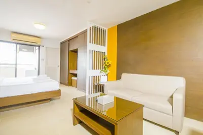 a bedroom with a bed and a couch and a table at Sitara Place Serviced Apartment & Hotel in Bangkok