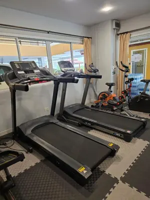 a gym with two tread machines and a treadmill at Sitara Place Serviced Apartment & Hotel in Bangkok