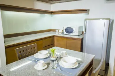 a kitchen with a table and a refrigerator at Sitara Place Serviced Apartment & Hotel in Bangkok