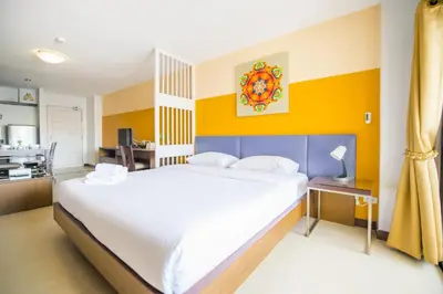 a bedroom with a large bed and a kitchen at Sitara Place Serviced Apartment & Hotel in Bangkok