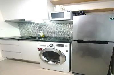 a kitchen with a washing machine and a microwave at Nice Residence in heart of Bangkok in Bangkok