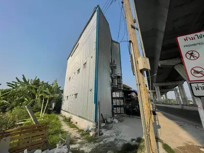 a building that is next to a highway at Charinsup Pinklao Hotel in Bang Kruai
