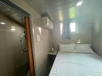 a small room with a bed and a window at Charinsup Pinklao Hotel in Bang Kruai