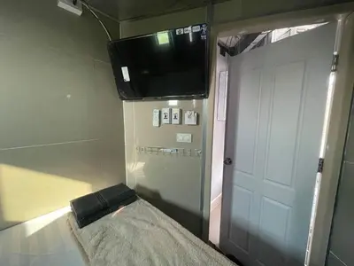 a room with a tv and a bed and a door at Charinsup Pinklao Hotel in Bang Kruai