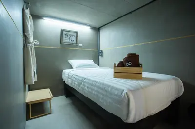 a bedroom with a bed with a teddy bear on it at Third Rock Hostel in Bangkok