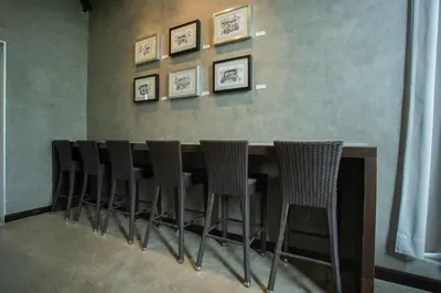 a row of chairs sitting at a bar at Third Rock Hostel in Bangkok