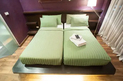 two large beds in a room with a book on it at Third Rock Hostel in Bangkok