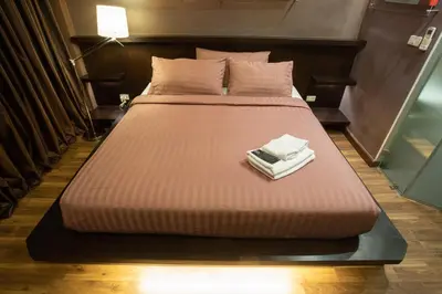 a large bed with two towels on top of it at Third Rock Hostel in Bangkok