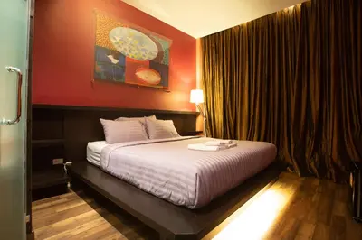 a hotel room with a bed with white sheets at Third Rock Hostel in Bangkok