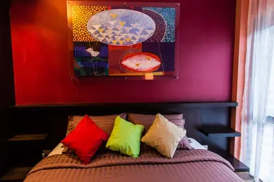 a bedroom with a bed with colorful pillows at Third Rock Hostel in Bangkok