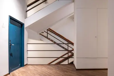 a staircase in a room with a blue door at Beanstalk Bangkok in Bangkok