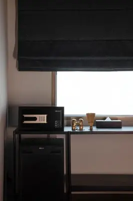 a window with a black window shade and a microwave at Beanstalk Bangkok in Bangkok