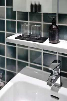 a bathroom sink with a soap dispenser on a shelf at Beanstalk Bangkok in Bangkok