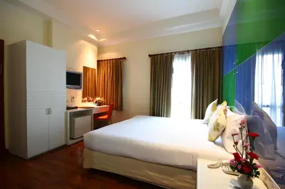 a hotel room with a bed and a desk and window at Calypzo Bangkok in Bangkok