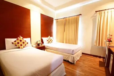 a hotel room with two beds and a window at Calypzo Bangkok in Bangkok