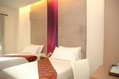 a hotel room with two beds and a table at Calypzo 2 Ratchada 20 in Bangkok
