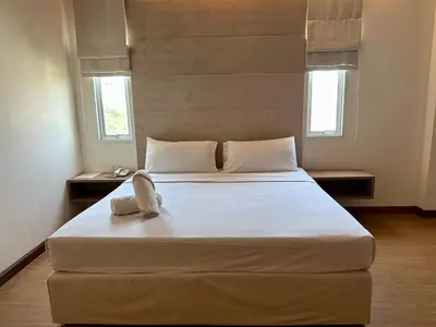 a bedroom with a large white bed with two windows at Calypzo 2 Ratchada 20 in Bangkok