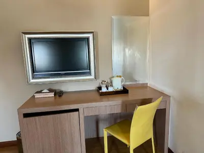 a room with a desk with a television and a yellow chair at Calypzo 2 Ratchada 20 in Bangkok