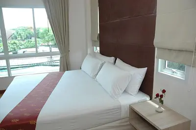 a bedroom with a large bed with a window at Calypzo 2 Ratchada 20 in Bangkok