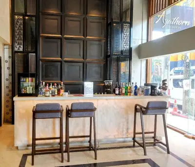 a bar in a restaurant with two stools at Ayathorn Bangkok in Bangkok