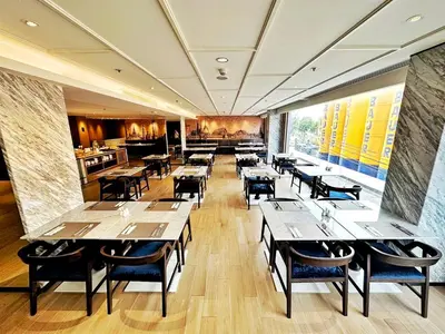 a restaurant with tables and chairs in a room at Ayathorn Bangkok in Bangkok