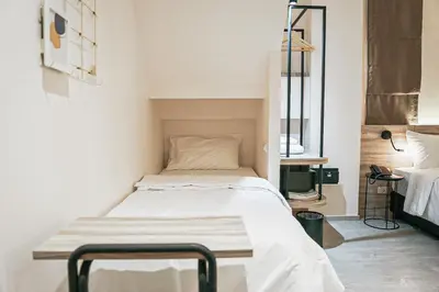 a hospital bed in a room with white walls at HOMITEL Bangkok in Bangkok