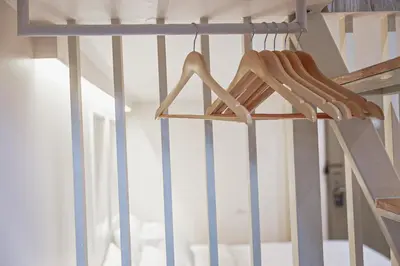 a ladder with wooden hangers in a room at HOMITEL Bangkok in Bangkok