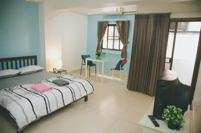 a bedroom with a bed and a table and chairs at Baan Romdee in Nonthaburi