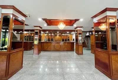 a large room with a bar with wood paneling at The Promenade Bangkok in Bangkok
