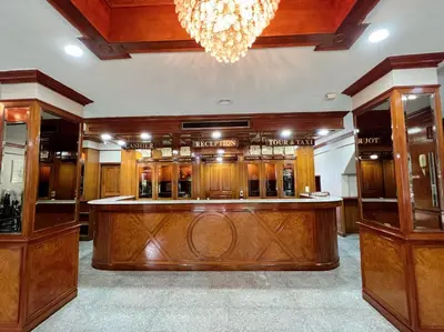 a bar in a room with wooden furniture and a chandelier at The Promenade Bangkok in Bangkok
