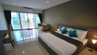 a bedroom with a large bed with blue pillows at Baan Mina in Bangkok