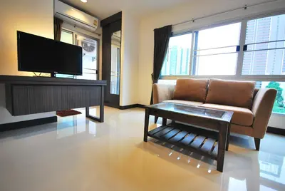 a living room with a couch and a tv at Baan Mina in Bangkok