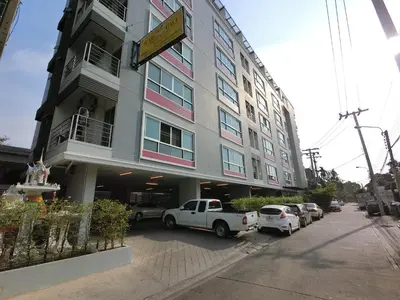 a white truck parked in front of a building at Baan Mina in Bangkok
