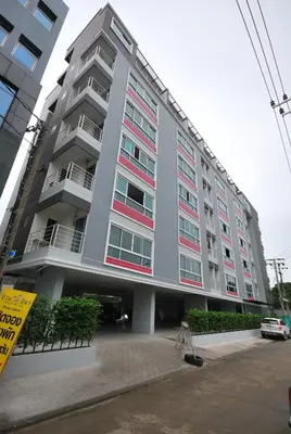 a large gray building with red and white windows at Baan Mina in Bangkok