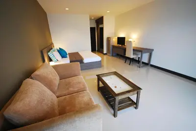 a living room with a couch and a bed at Baan Mina in Bangkok