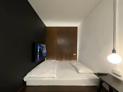 a bedroom with a bed with a wooden head board at Chatel Samyan - Self check-in in Bang Rak