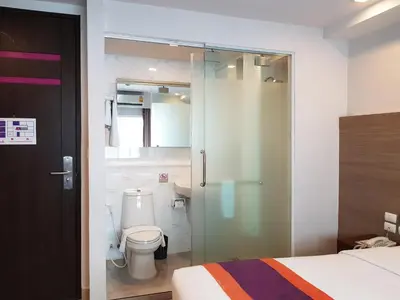 a bathroom with a toilet and a glass shower door at Studio Nana by iCheck inn in Bangkok