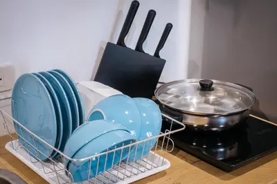 a dish rack with plates and utensils next to a stove at T3 TWO Bedrooms WIFI Full kitchen 1 min to BTS in Bangkok
