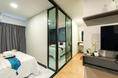 a room with a bedroom with a tv and a bed at Metro Hotel Ratchada 36 in Bangkok