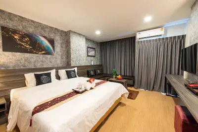 a bedroom with a large bed and a television at Metro Hotel Ratchada 36 in Bangkok