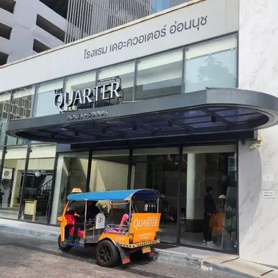 a small golf cart parked in front of a store at The Quarter Onnut by UHG in Bangkok