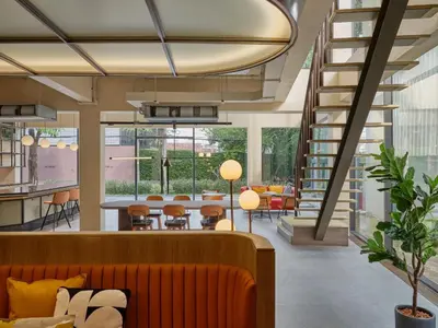 a living room with a couch and a table and chairs at The Quarter Onnut by UHG in Bangkok