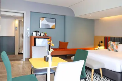 a hotel room with a bed and a table and chairs at The Quarter Onnut by UHG in Bangkok