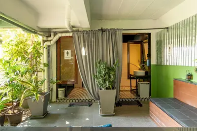 a room with potted plants and a curtain at The Palm Hotel in Salaya